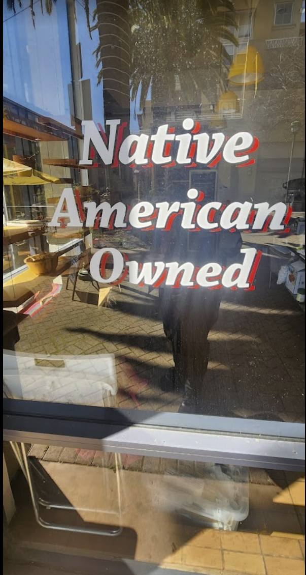 Window signage proudly proclaims that a business is Native American owned.