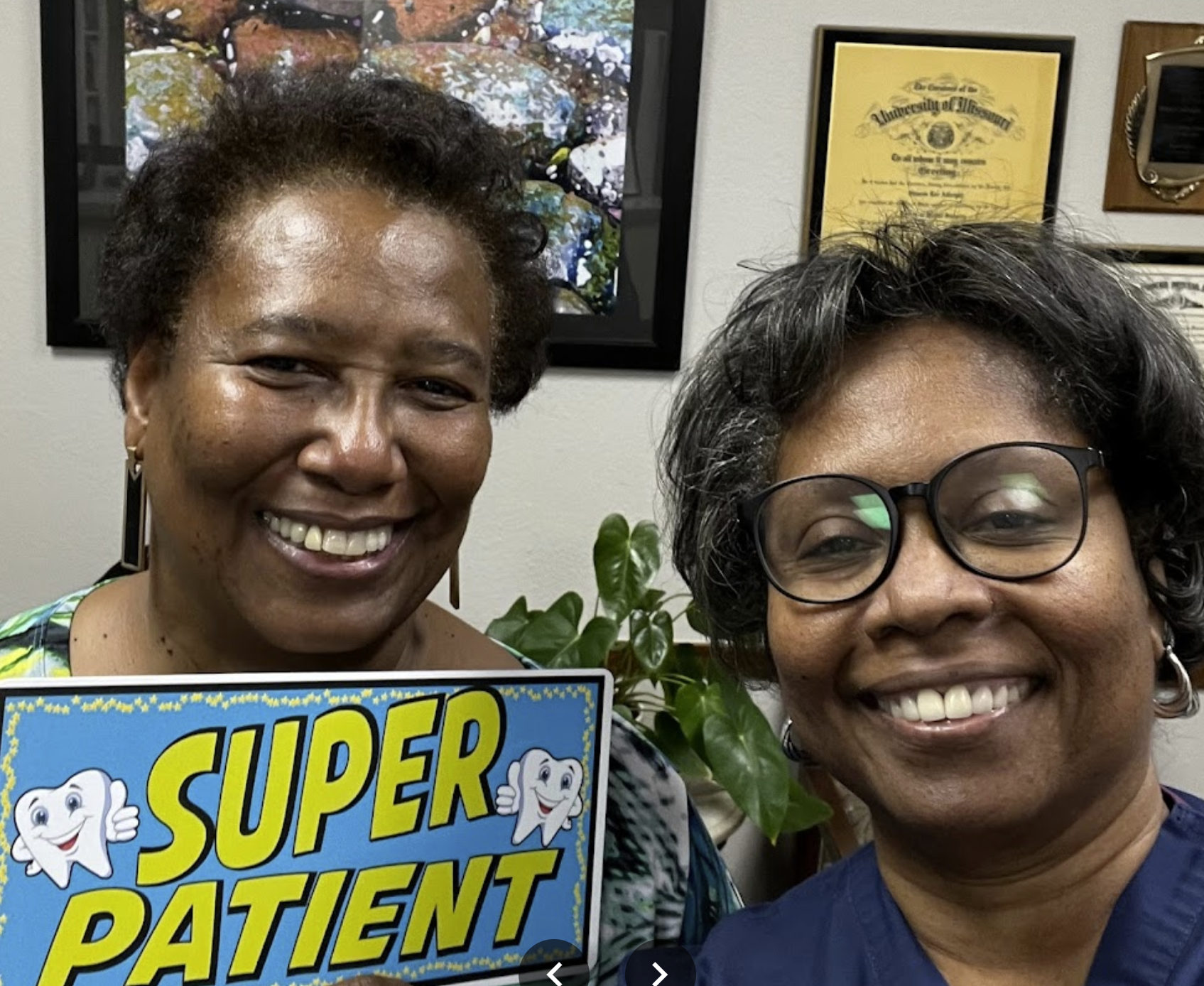 A dentist poses with their patient who has been given an award reading super patient.