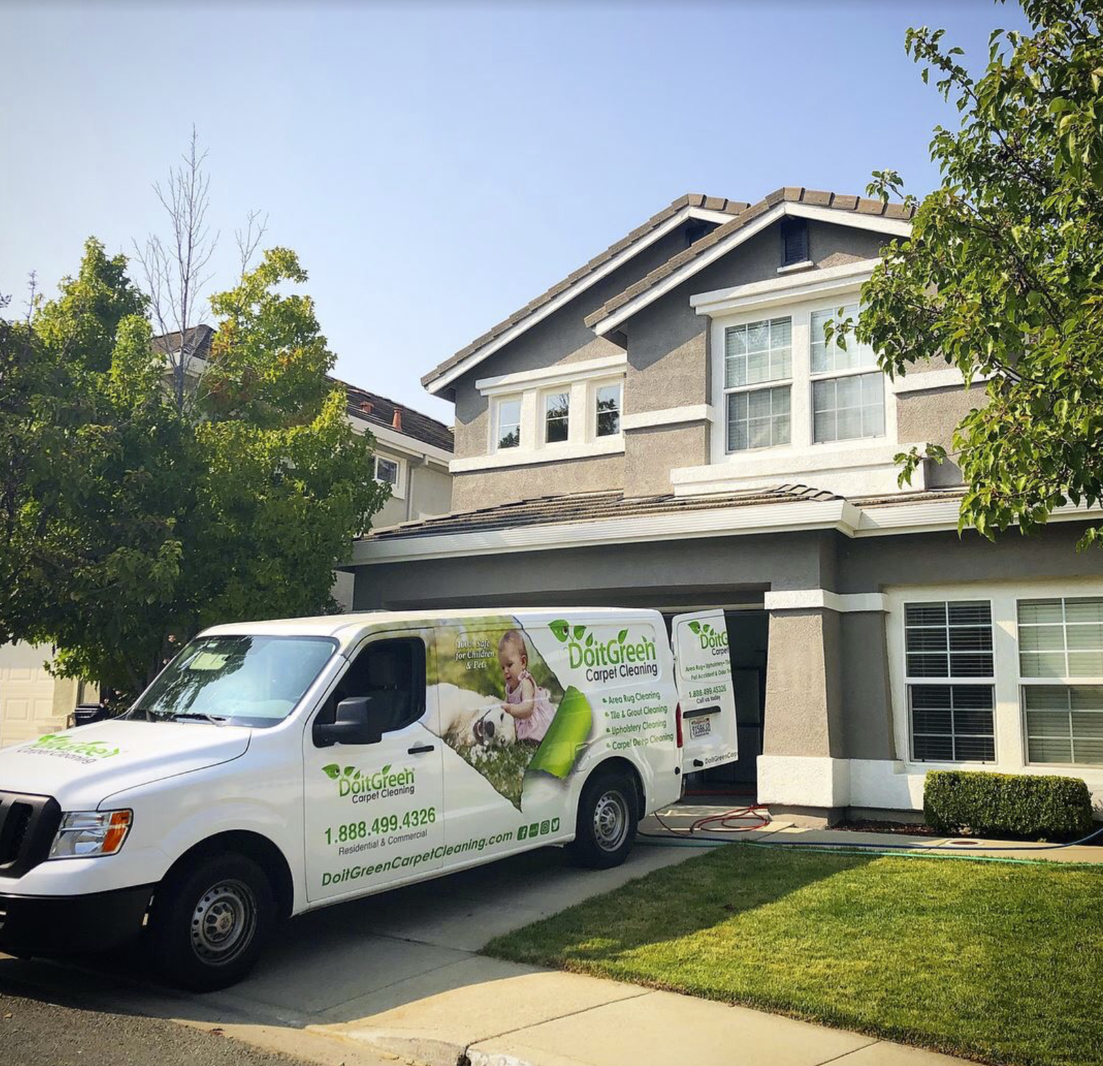A clear shot of a van at a house shows company signage on the vehicle.