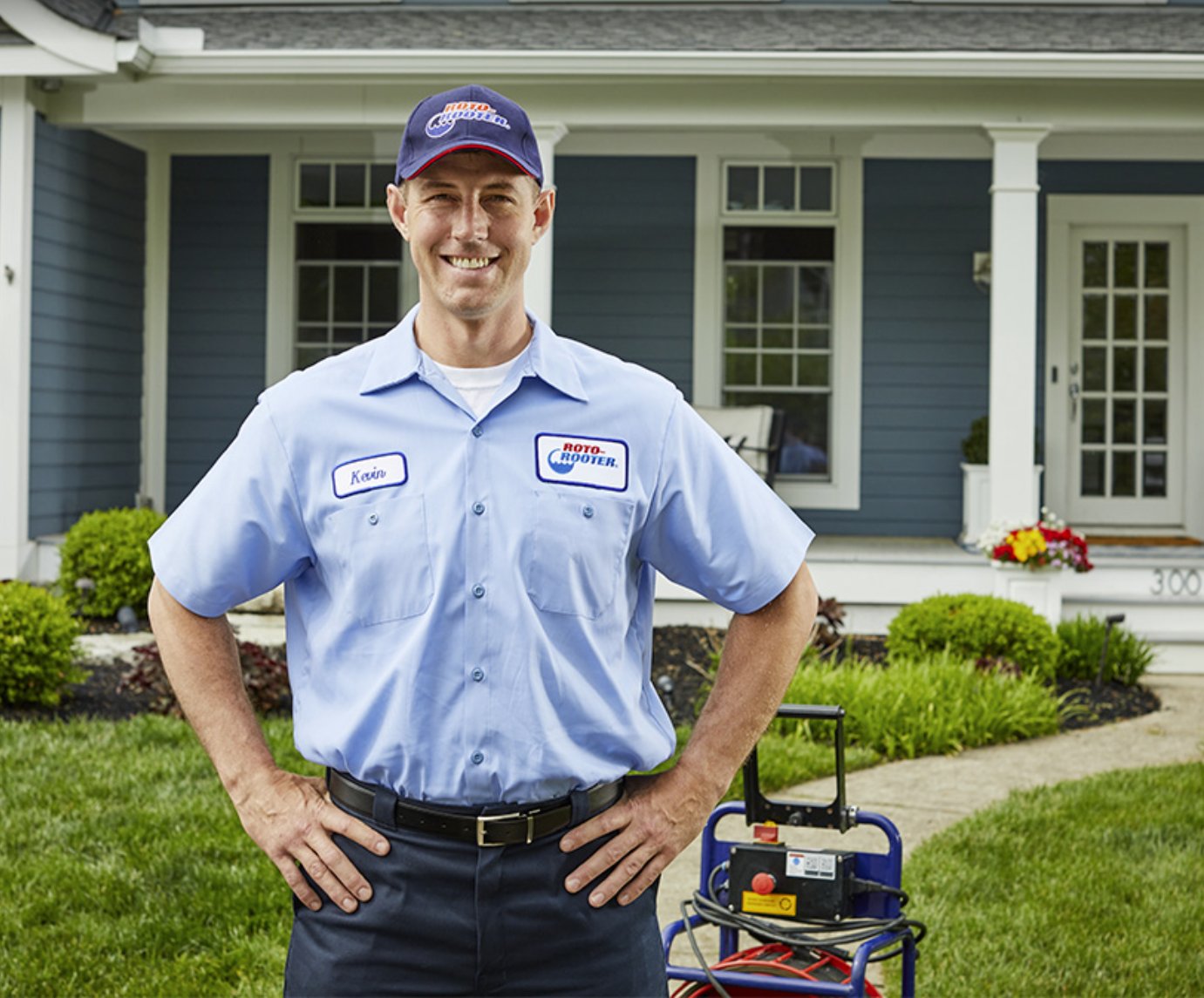 An employee of Roto-Rooter wears their uniform with company logo and name.