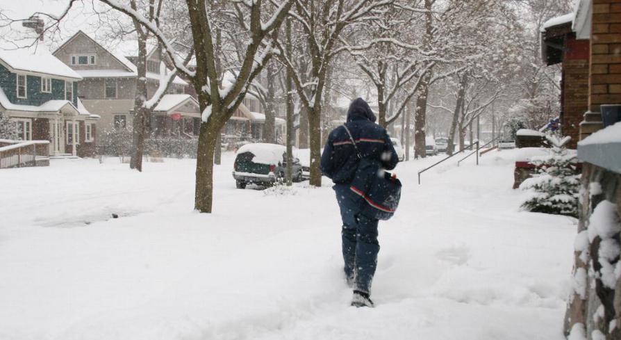 Person walking through the snow away from the camera.