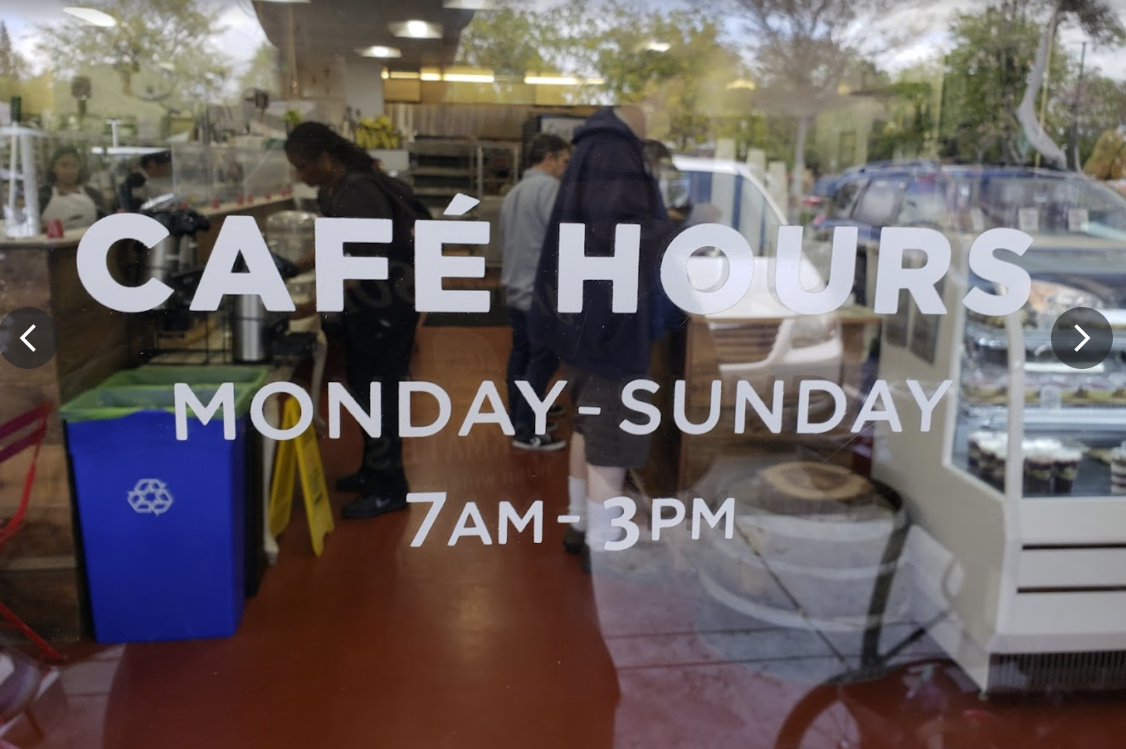A photo of store hours as displayed on a shop front window