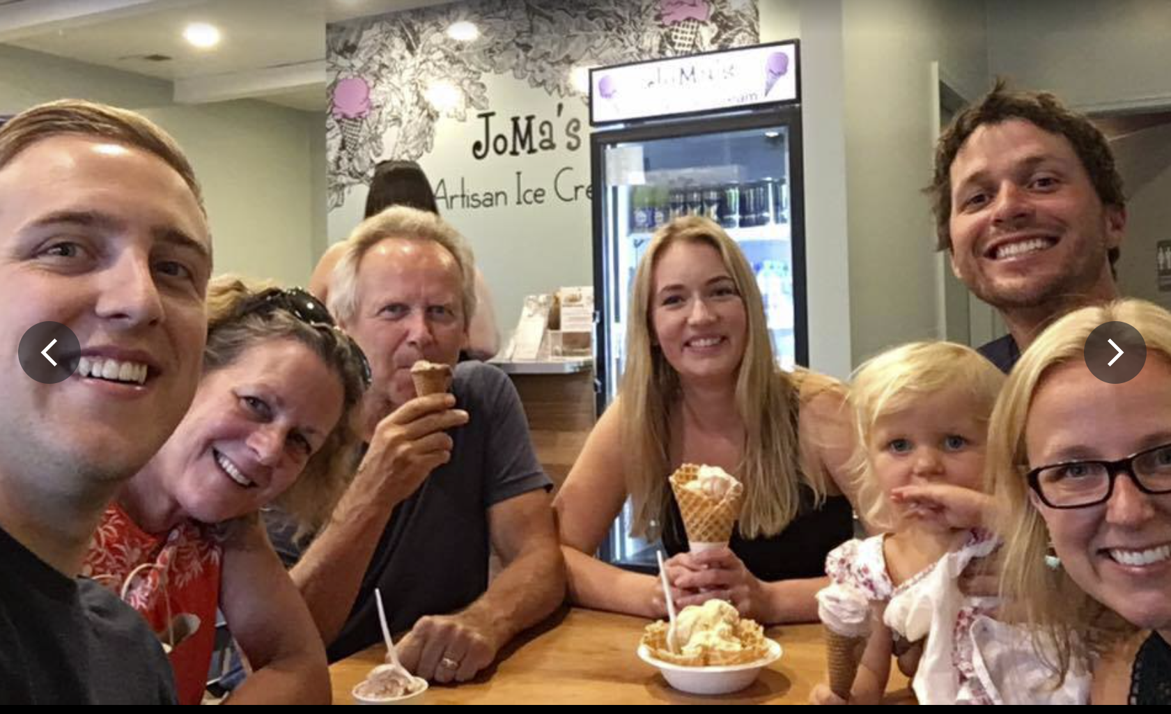 A multi-generational group enjoying ice cream together at an ice cream parlour.